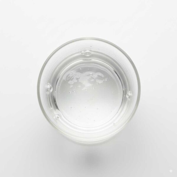 Top view of glycerin in a laboratory glass beaker, clear viscous liquid with light reflection on a white background